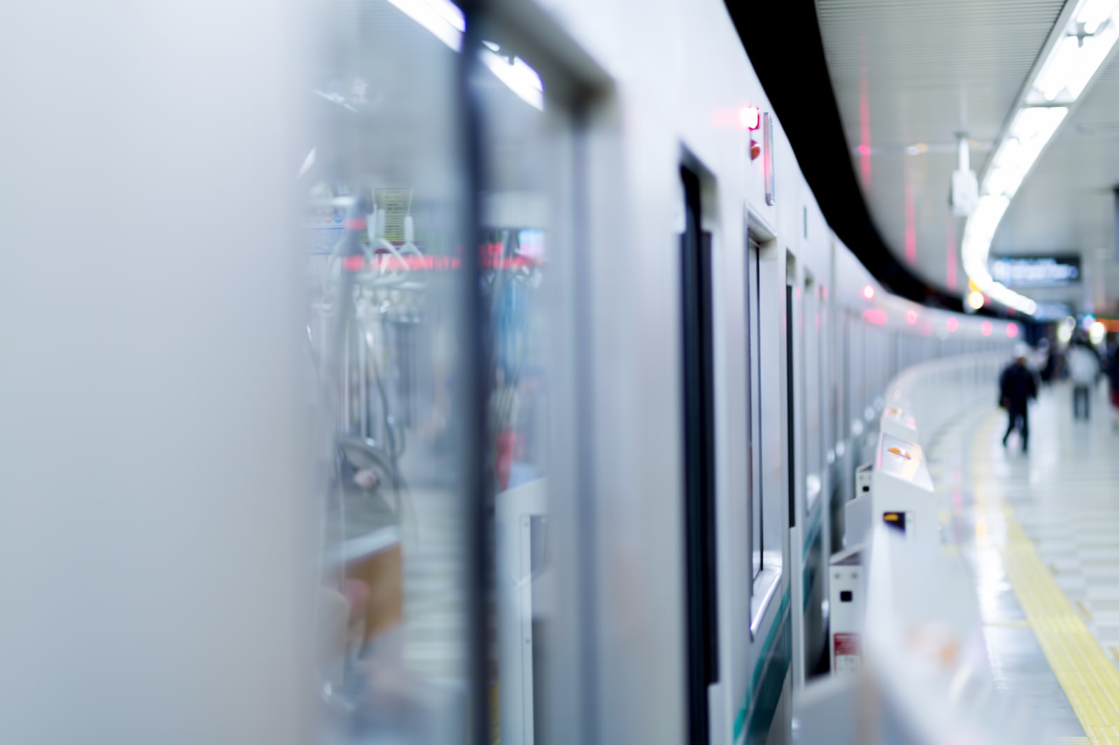 ホームに扉を開けて停車する電車