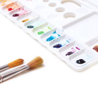 絵の具が付いた筆と木のパレットのアート画材の写真