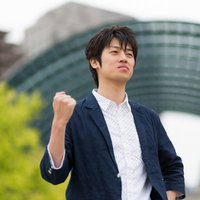 デスクの前でガッツポーズを決めるWebデザイナーの写真