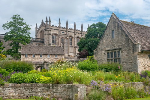 赤い花壇と芝生に囲まれたクライストチャーチの石造りの建物
