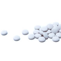 パッケージから取り出されたシート入りの白い錠剤の薬の写真