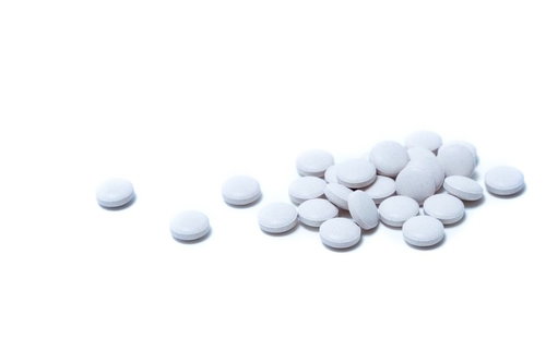 パッケージから取り出されたシート入りの白い錠剤の薬