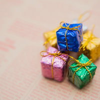 英文が印刷された紙の上にリボン付きのプレゼントボックスの写真