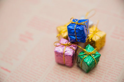 英文が印刷された紙の上にリボン付きのプレゼントボックス