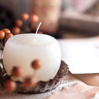 横構図のロウソクの炎とサンキライの赤い実のクリスマス飾りの写真