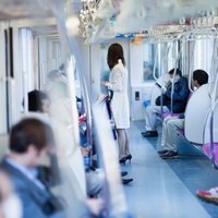 電車のドア付近でハイヒールの足元が見える乗車中の女性の写真