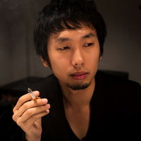 バーラウンジのソファーで煙草の煙をくゆらす一服中の男性の写真