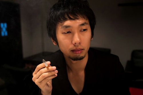 バーラウンジのソファーで煙草の煙をくゆらす一服中の男性