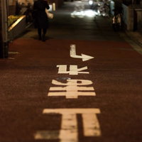 「止まれ」の道路標示が白くペイントされた路地裏の風景の写真