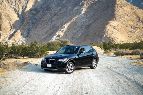 山岳地帯の砂利道を走る黒い4WD車のオフロード走行