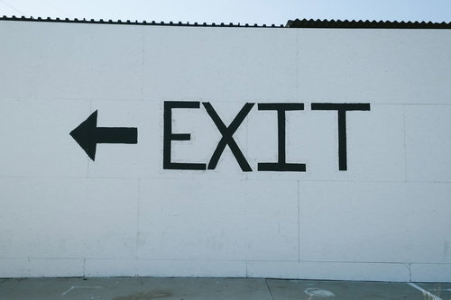 EXIT（お帰りはあちら）と左向き矢印の出口案内サイン