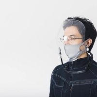 バブル形状のフェイスシールドとマスクを装着する男性の写真
