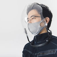 顔を覆うバブル形状のフェイスシールドを着用した男性の写真