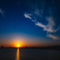 日が暮れる時の水面に映るオレンジ色の夕焼けの写真