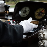 電車の運転手が白手袋で握る運転席の操縦桿の写真