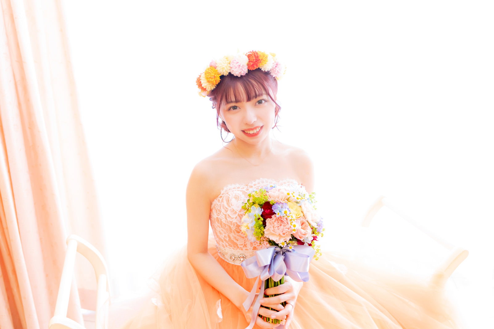 純白のウェディングドレスを着てブーケを両手で持つ花嫁［モデル：高尾実生］