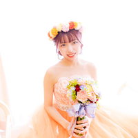 両手でブーケを持ったウェディングドレス姿の新婦の写真