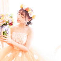 白いブーケを手に持った新婦のウェディングドレス姿の写真