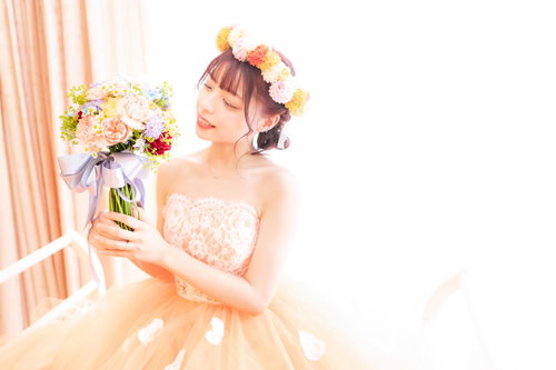 白いブーケを手に持った新婦のウェディングドレス姿