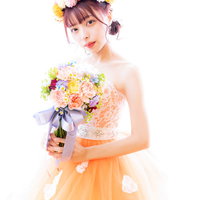 オレンジのウェディングドレスを着たブーケを持った花嫁の写真
