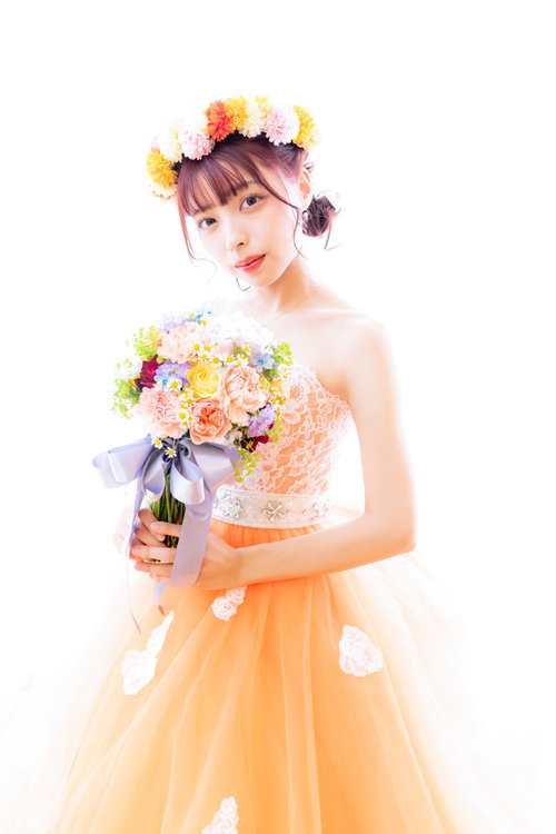 オレンジのウェディングドレスを着たブーケを持った花嫁