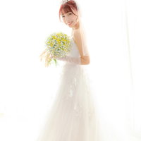 ブーケを持つウェディングドレス姿の花嫁のポーズの写真