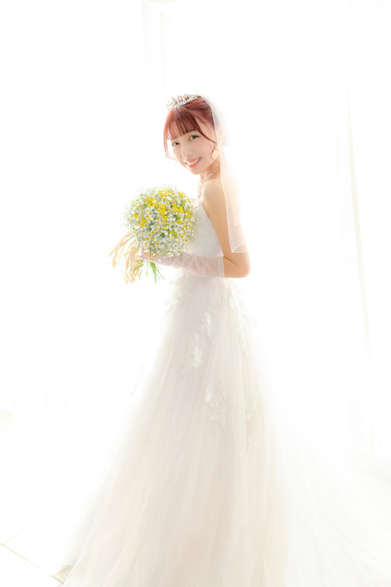 純白のウェディングドレスを着てブーケを持つ花嫁