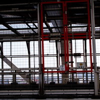 工場内の高電圧エリアと金網フェンスの写真