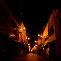 シャッターが下りた深夜の誰もいない商店街の写真