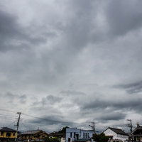 灰色の曇り空の下に並ぶ住宅地の民家の写真