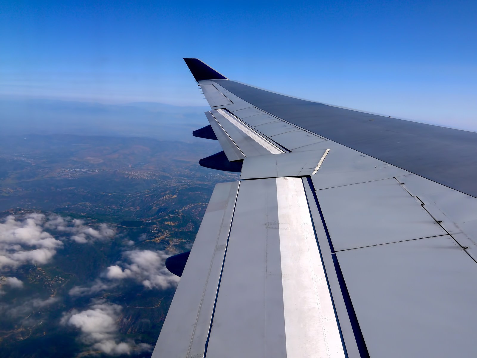 フライト中の翼と雲の景色（航空機内から）