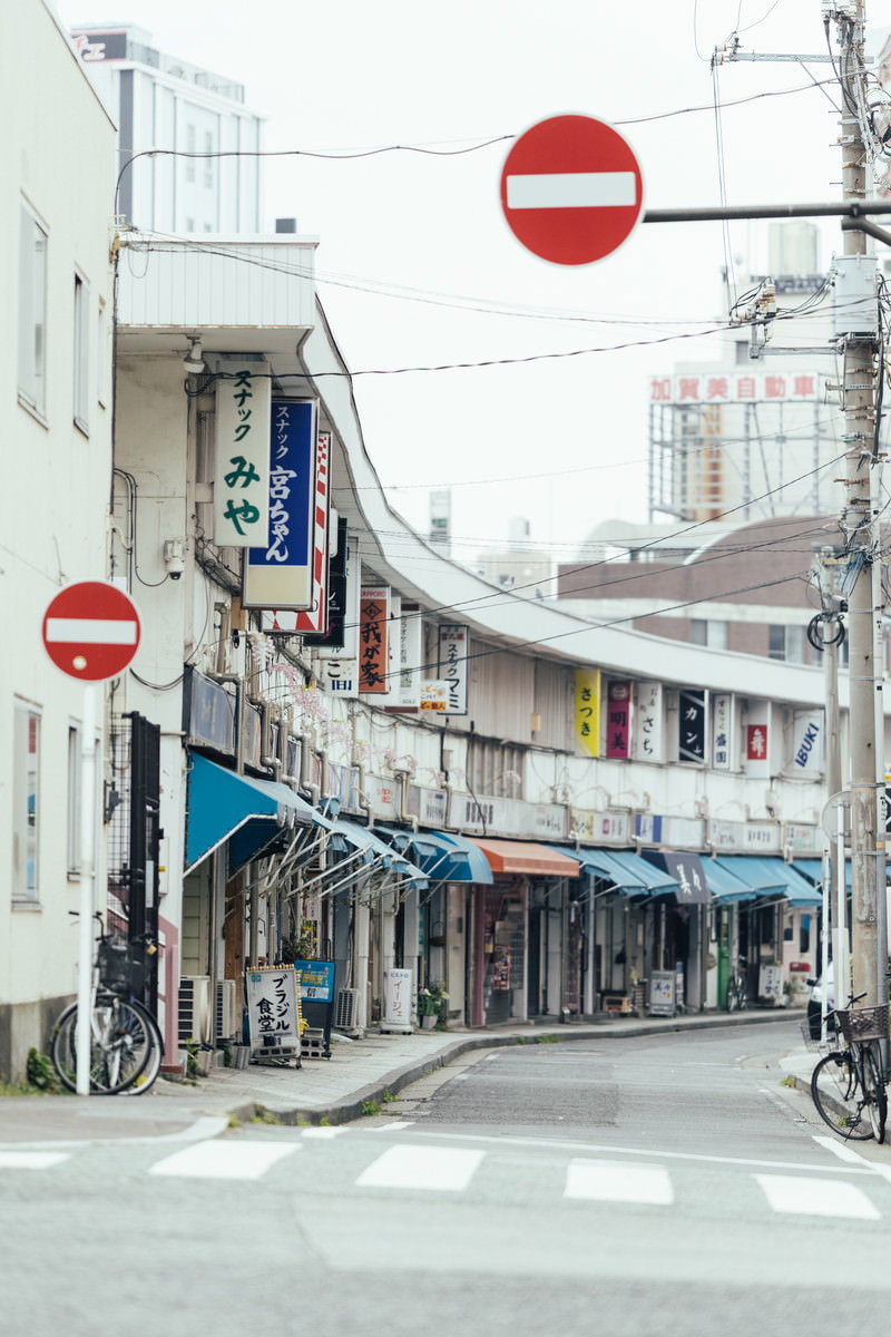 赤い進入禁止標識が見守る商店街の通路。スナックと飲み屋の看板が両側に並ぶ昭和レトロな横浜の街並み