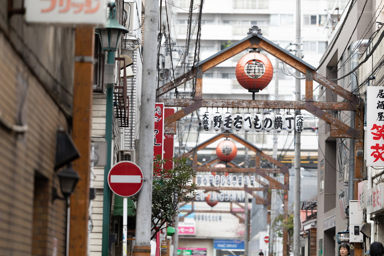 赤い提灯と看板が連なる野毛たべもの横丁のアーケード街