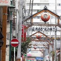 赤い提灯と看板が連なる野毛たべもの横丁のアーケード街の写真
