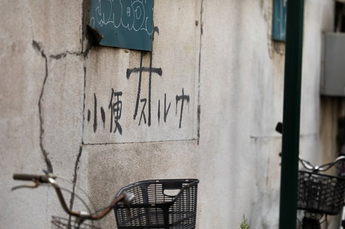 壁に書かれた「小便スルナ」