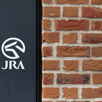 レンガの壁に映るJRAのロゴマーク、日本中央競馬会の公式マークの写真