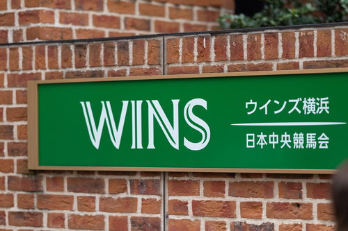 ウインズ横浜の入り口と緑色の看板、レンガ調の外壁