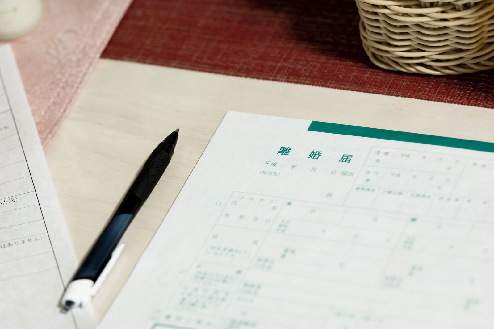 日付記入欄に平成と印刷された離婚届の用紙と黒いペン