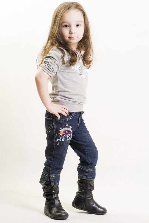 青空と向日葵畑で決めポーズするブロンドヘアの女の子