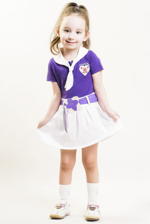 紫のトップスと白いスカートでポーズをきめる女の子