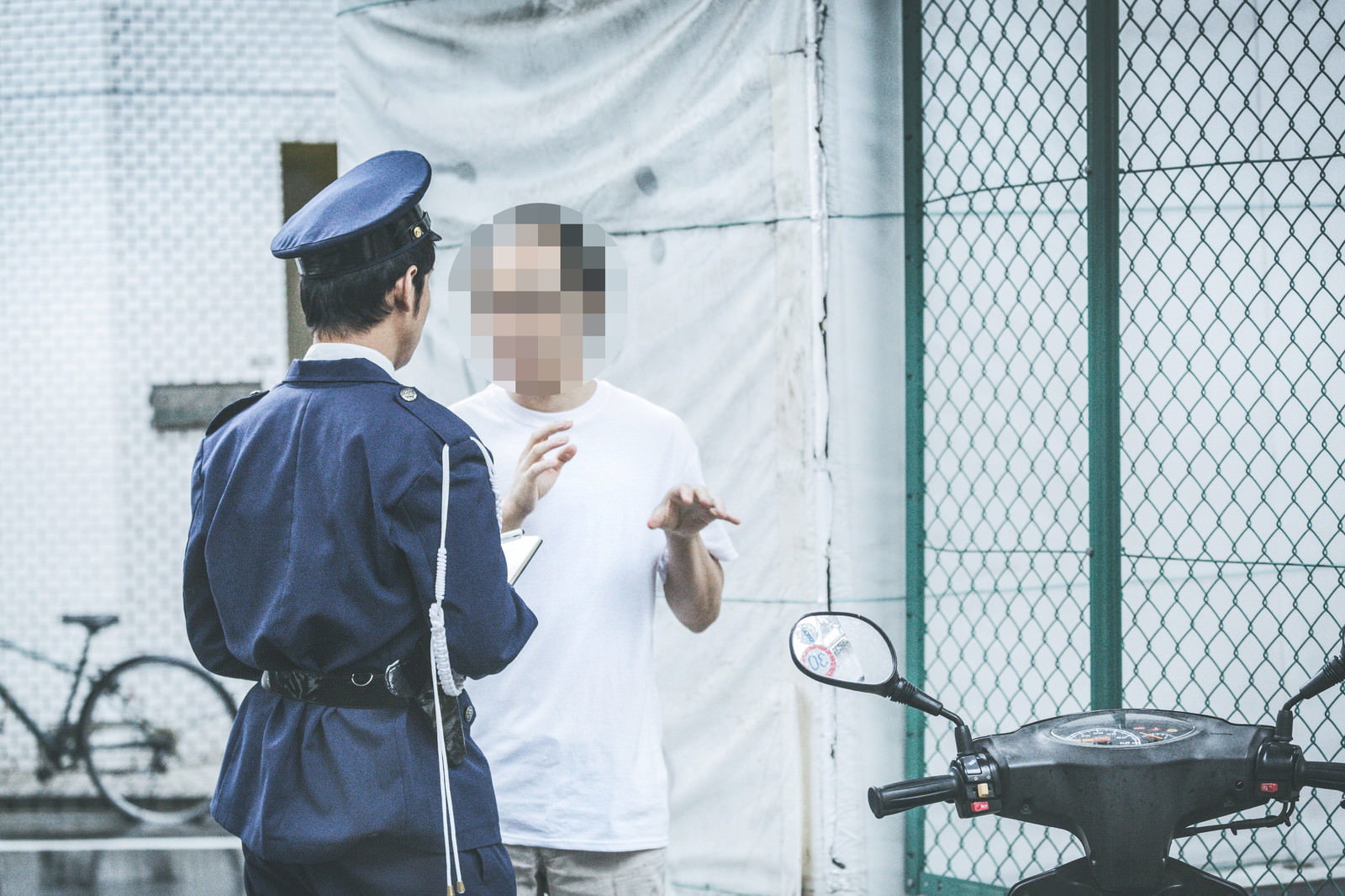 職務質問を受ける男性と警察官の対面する様子［モデル：大川竜弥 モデルリリース］