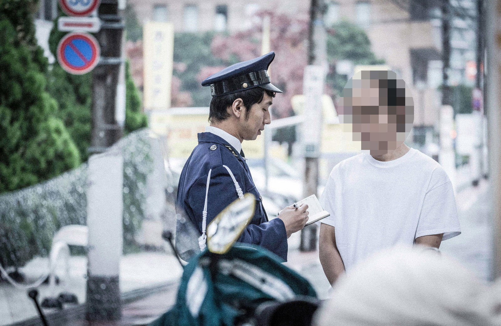 職務質問を受ける男性と警察官がクリップボードを持って対応している［モデル：大川竜弥 モデルリリース］