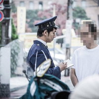 職務質問に応じる男性と警察官の制服姿の写真