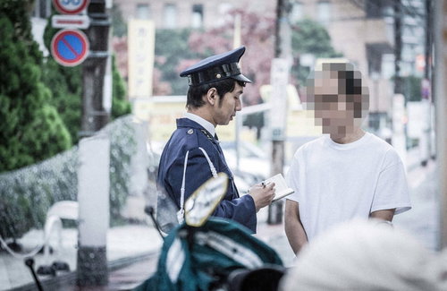 職務質問に応じる男性と警察官の制服姿