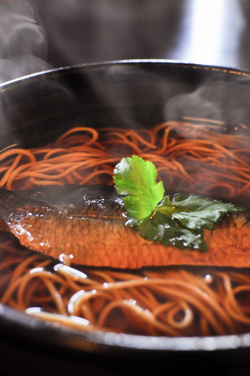 黒い器に盛られた魚の切り身が載ったにしんそば