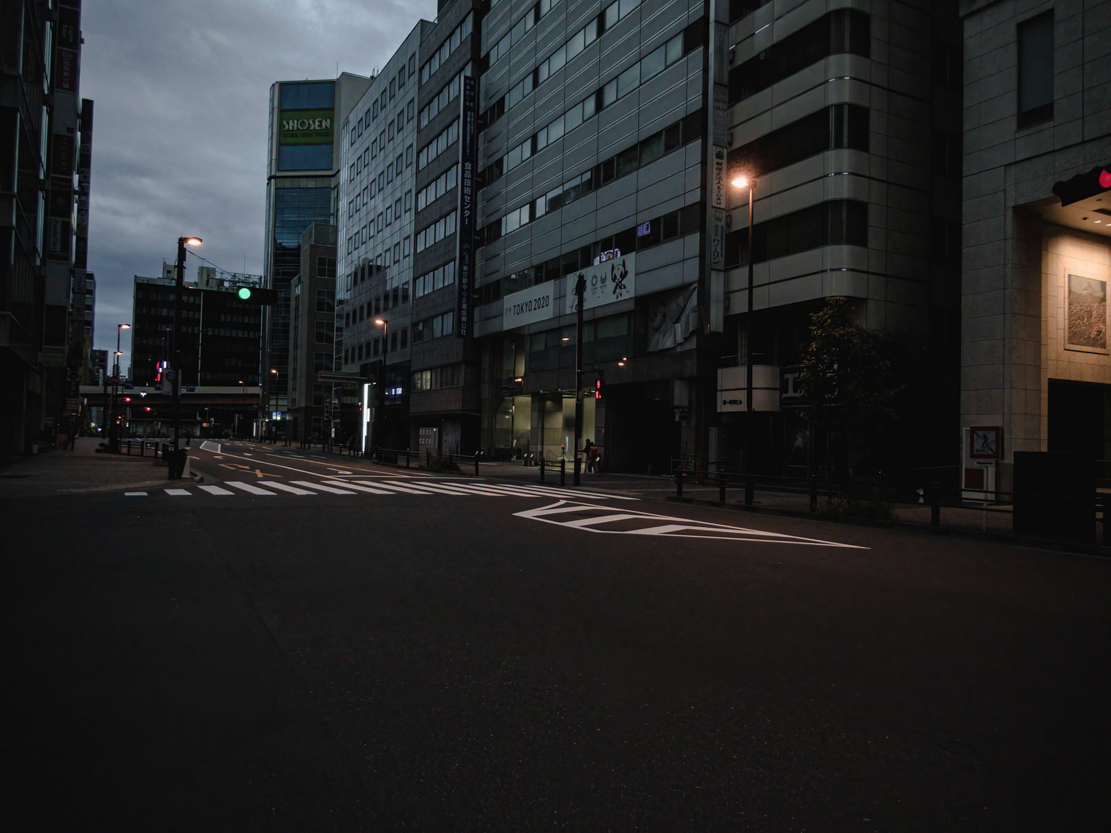 早朝の薄暗い時間帯に撮影された秋葉原の車道とビル群