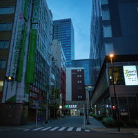 ビルに囲まれた秋葉原駅へと向かう夜の路地の写真