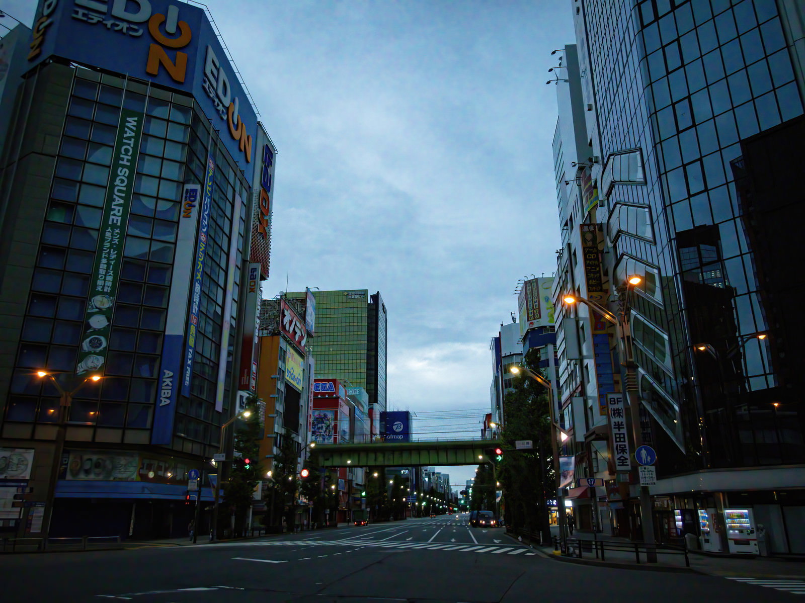 夕暮れの秋葉原駅前通りに高層ビルと電気街の看板が立ち並ぶ街並み