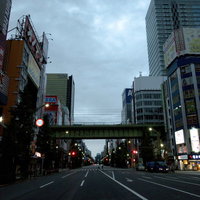 早朝の秋葉原、高層ビルが立ち並ぶ車道と高架橋の写真