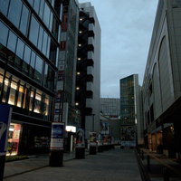 早朝の薄暗い秋葉原の路地裏、高いビルに囲まれた静寂の街の写真